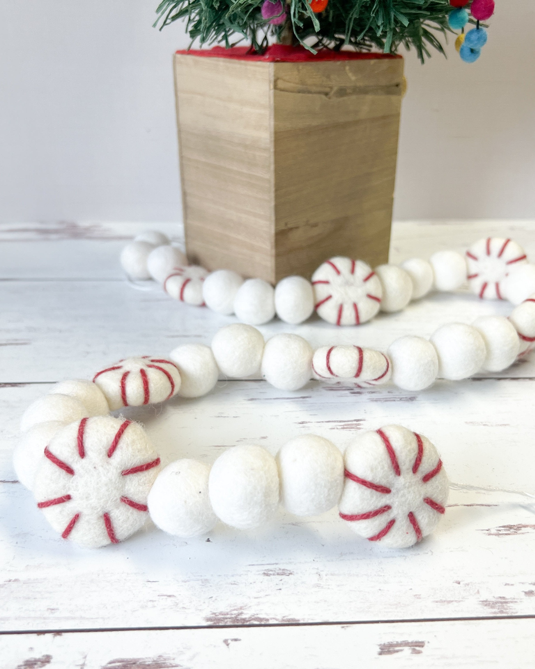 a bunch of white and red candy canes next to a potted plant