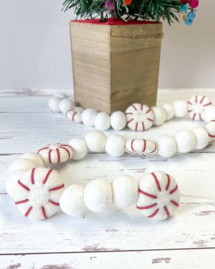 a bunch of white and red candy canes next to a potted plant