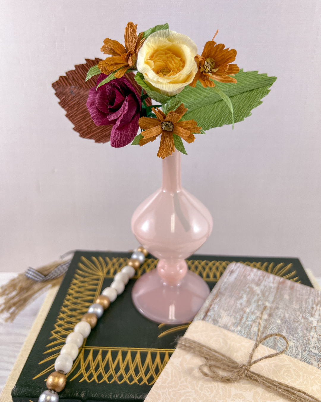 a pink vase filled with flowers on top of a table