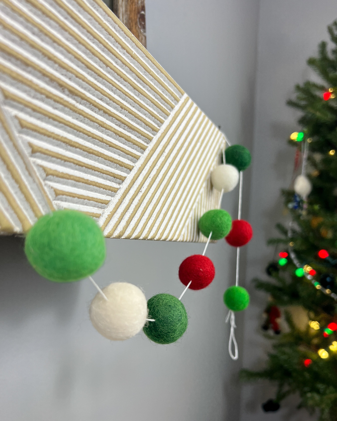 a christmas tree with a bunch of pom poms hanging from it