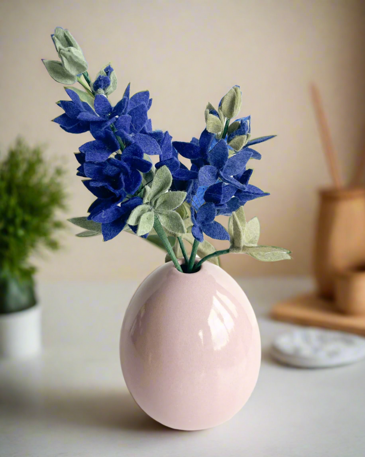 a pink vase with blue flowers in it