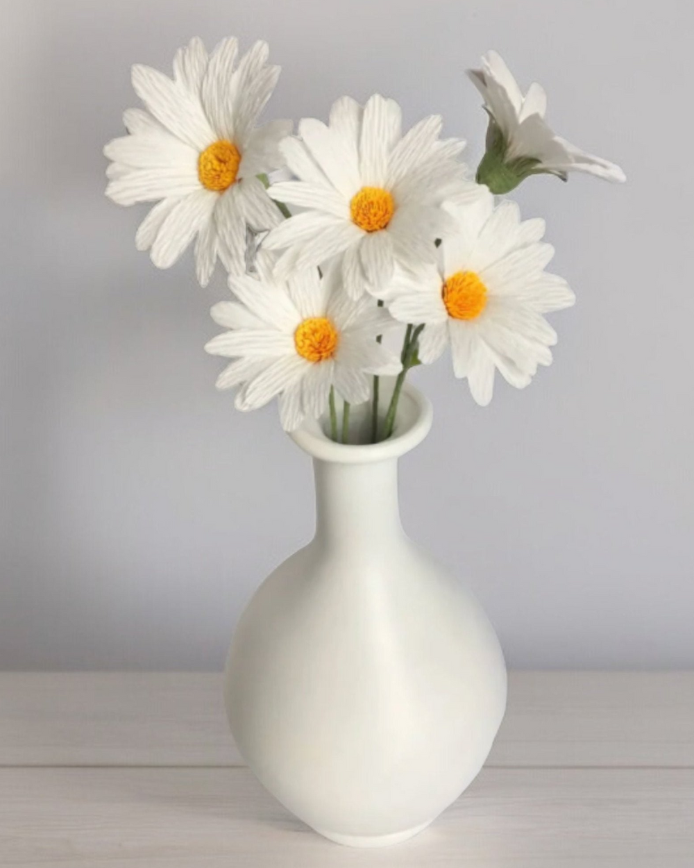 a white vase filled with lots of white flowers