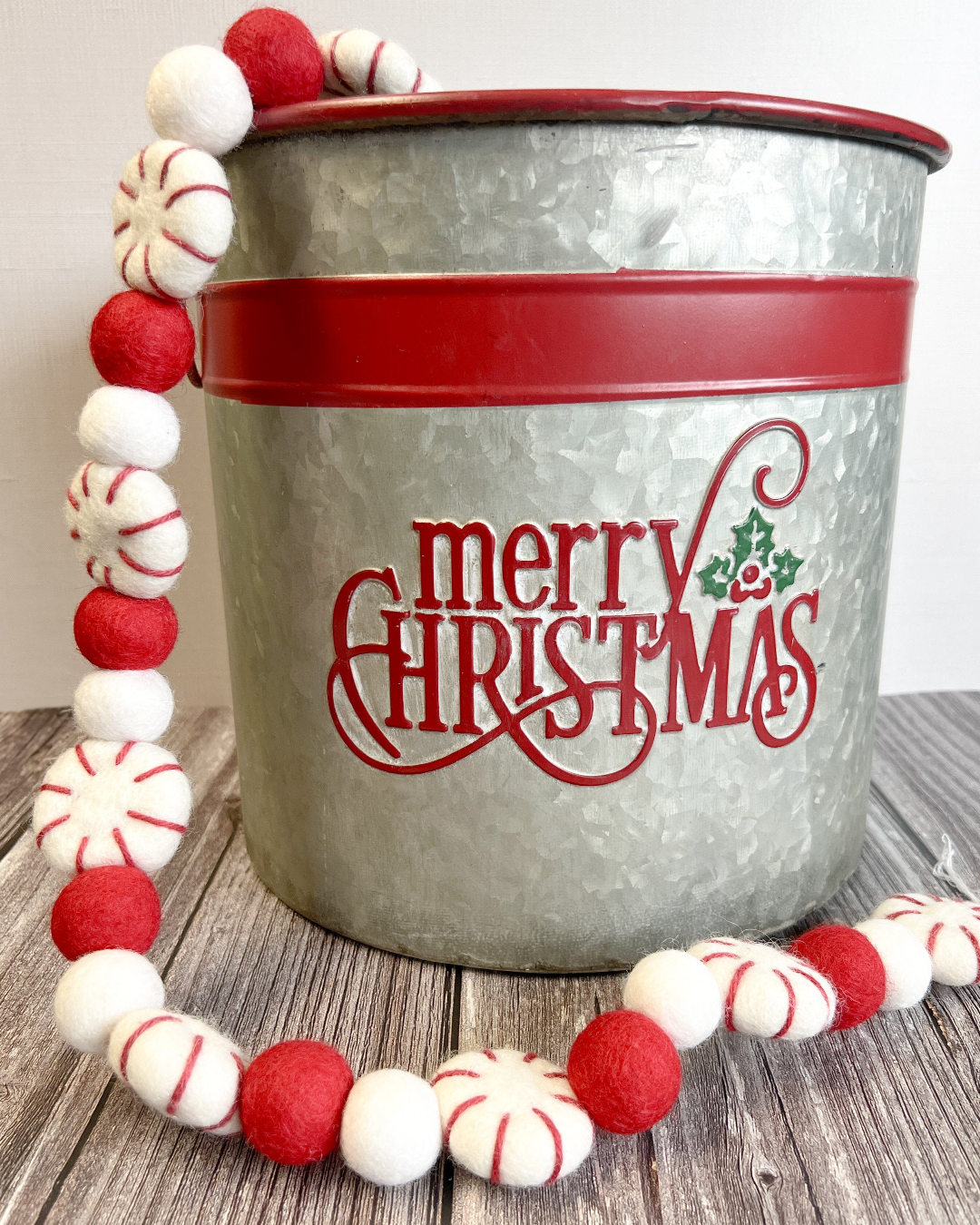a bucket with a red and white christmas decoration around it