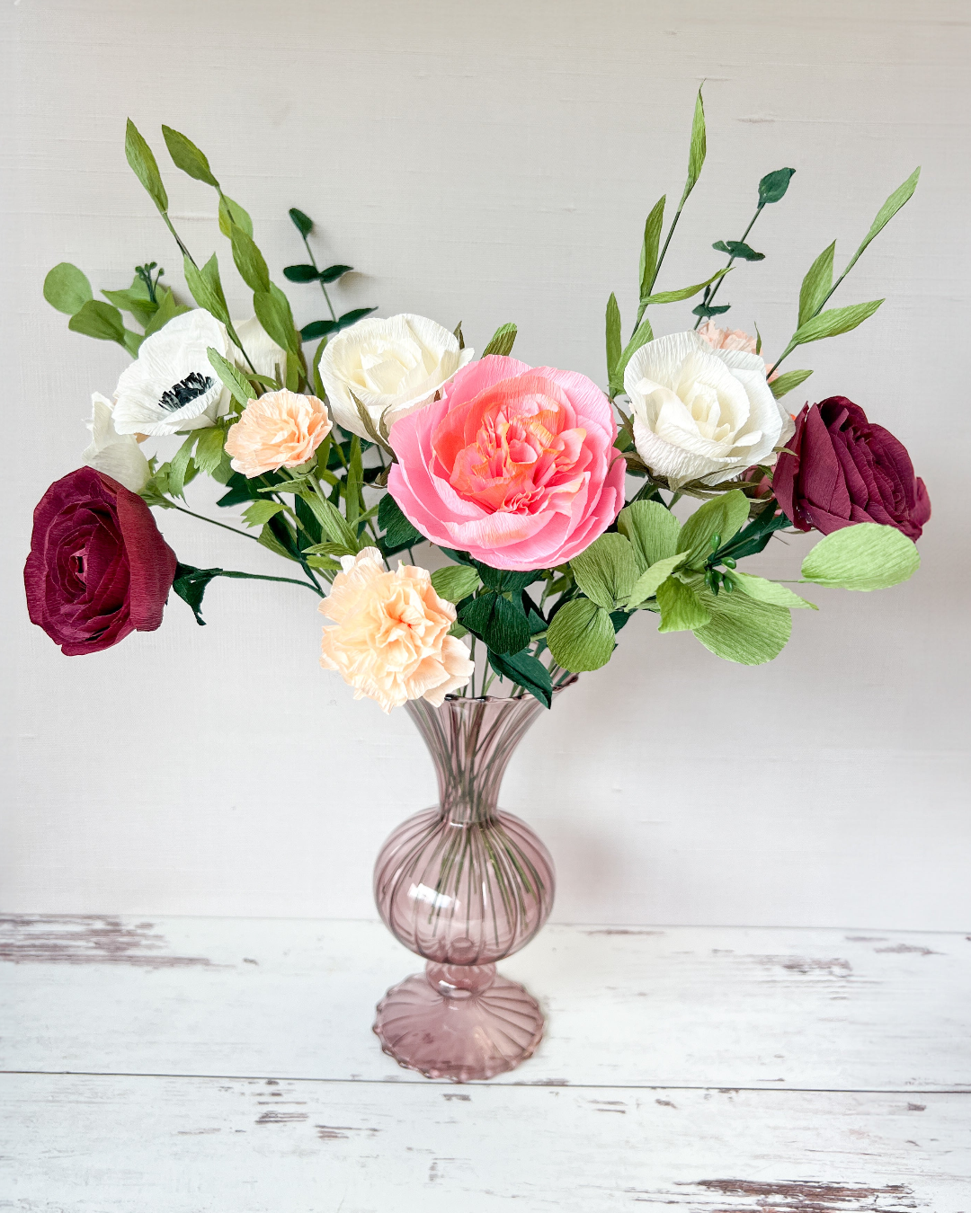 a vase filled with lots of different colored flowers