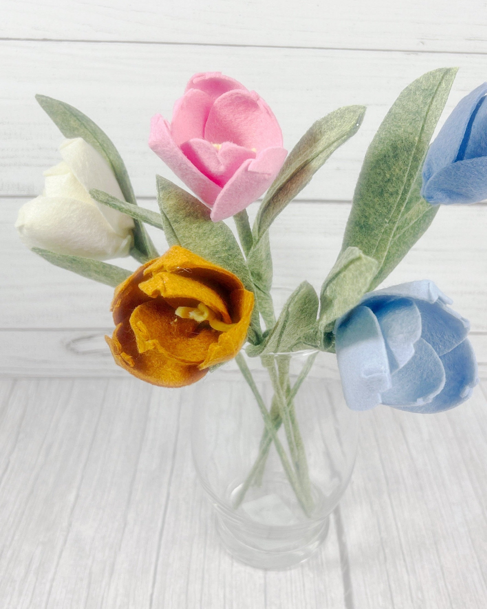 a vase filled with colorful flowers on top of a white table