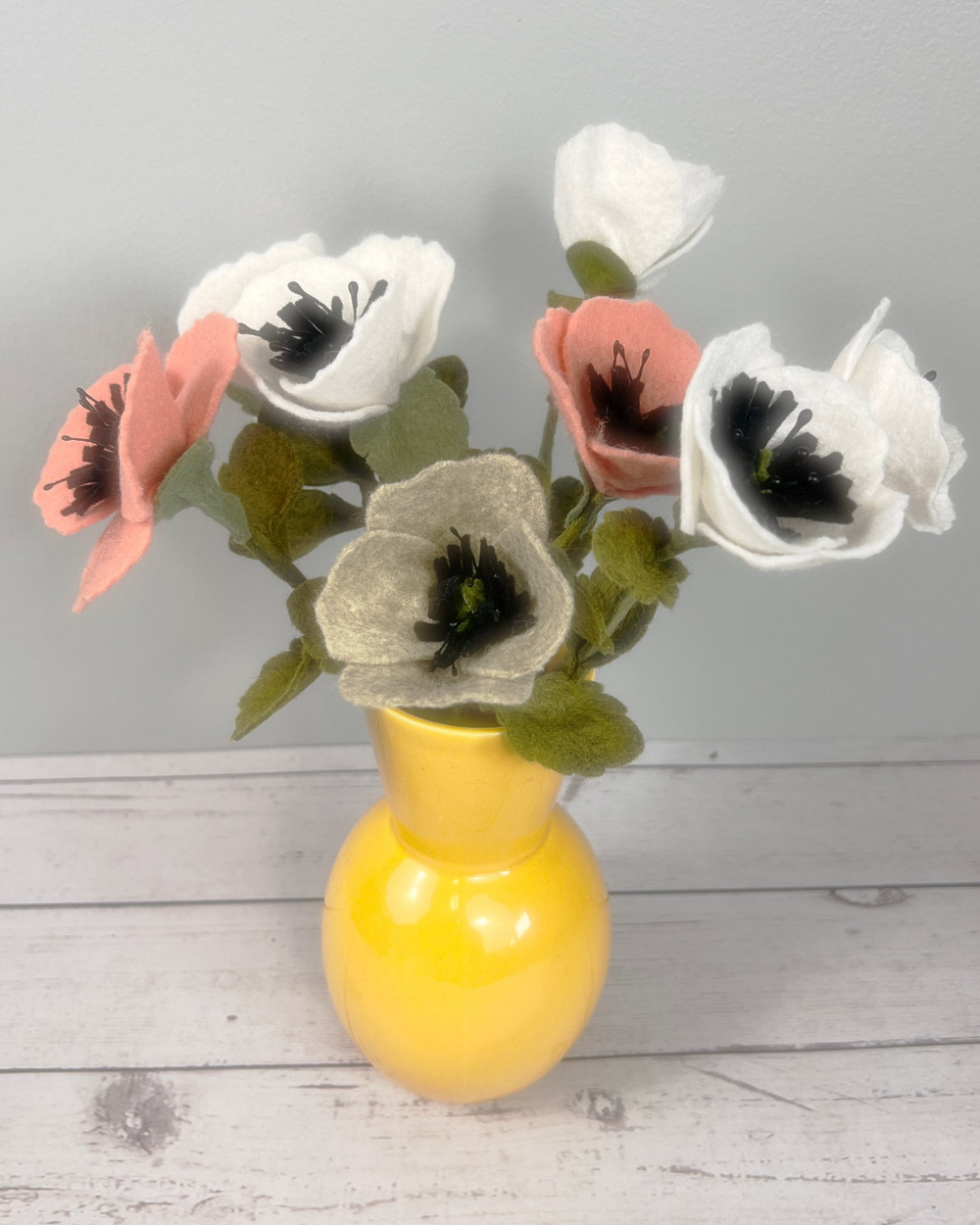 a yellow vase filled with white and pink flowers