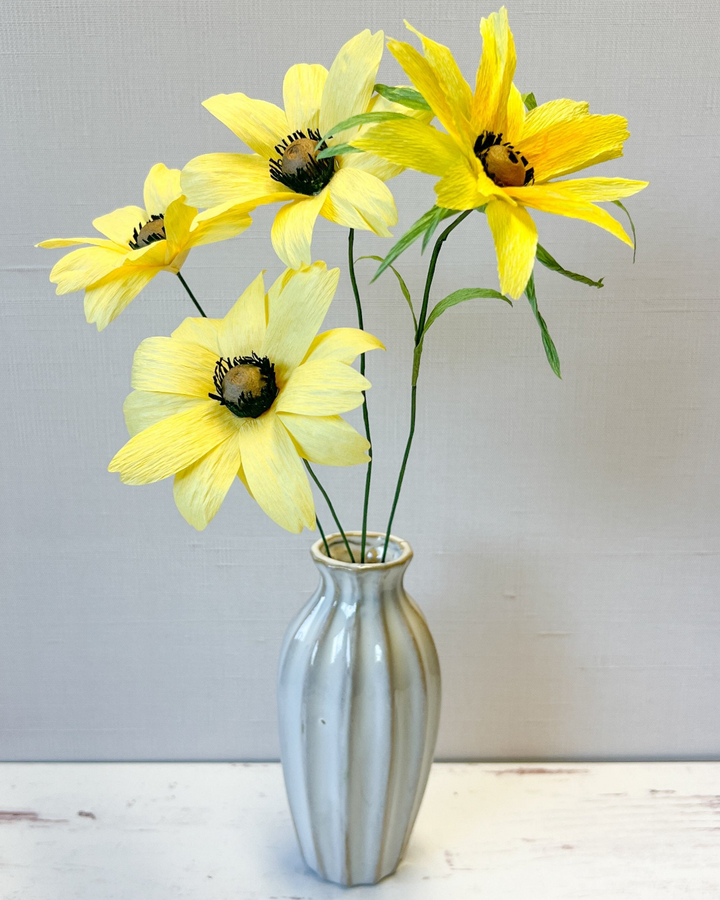 a vase filled with yellow flowers on top of a table