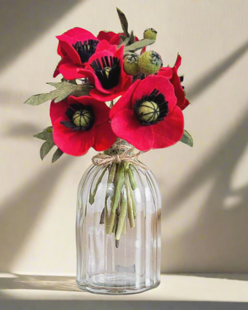 a vase filled with red flowers on top of a table