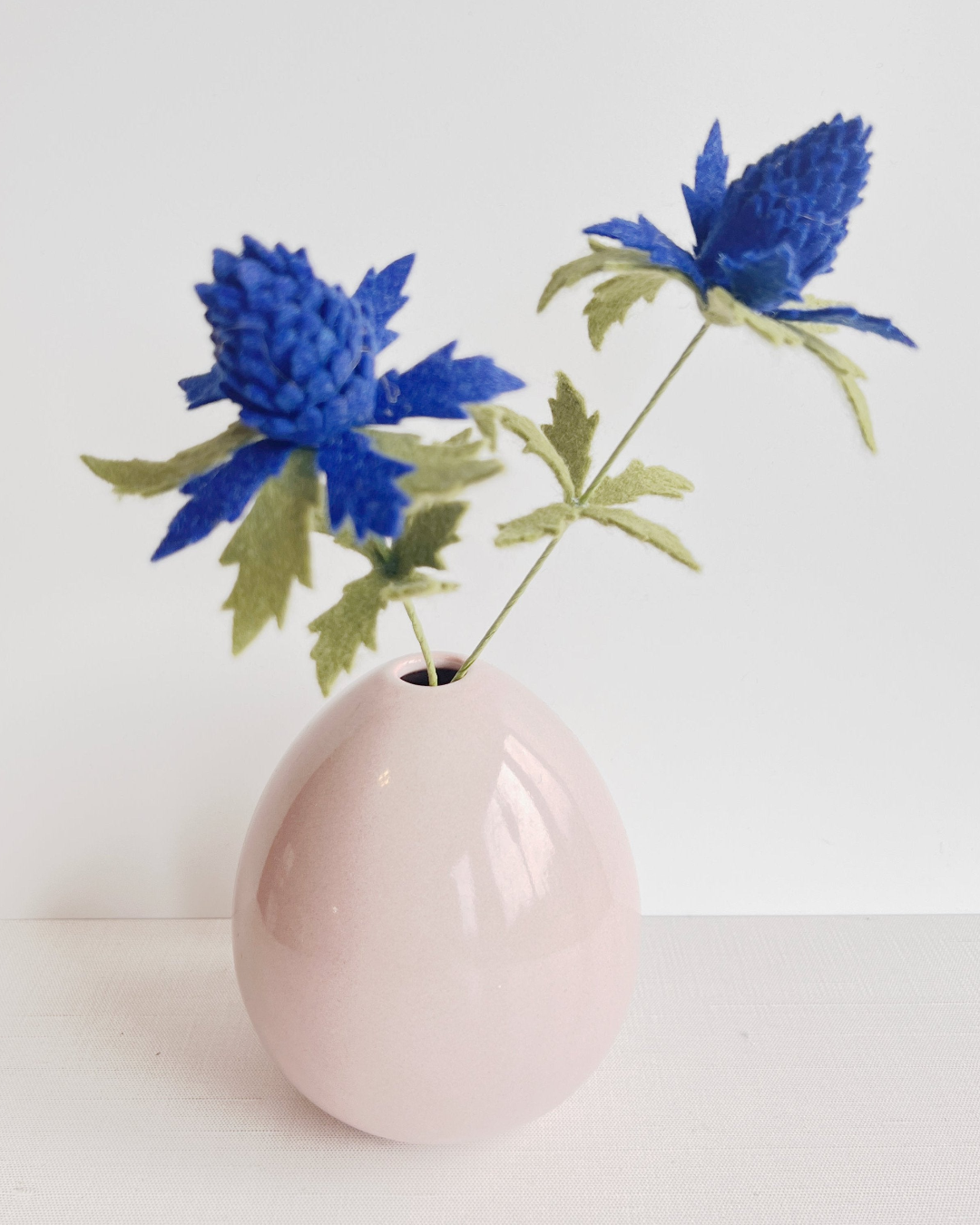 a pink vase with blue flowers in it