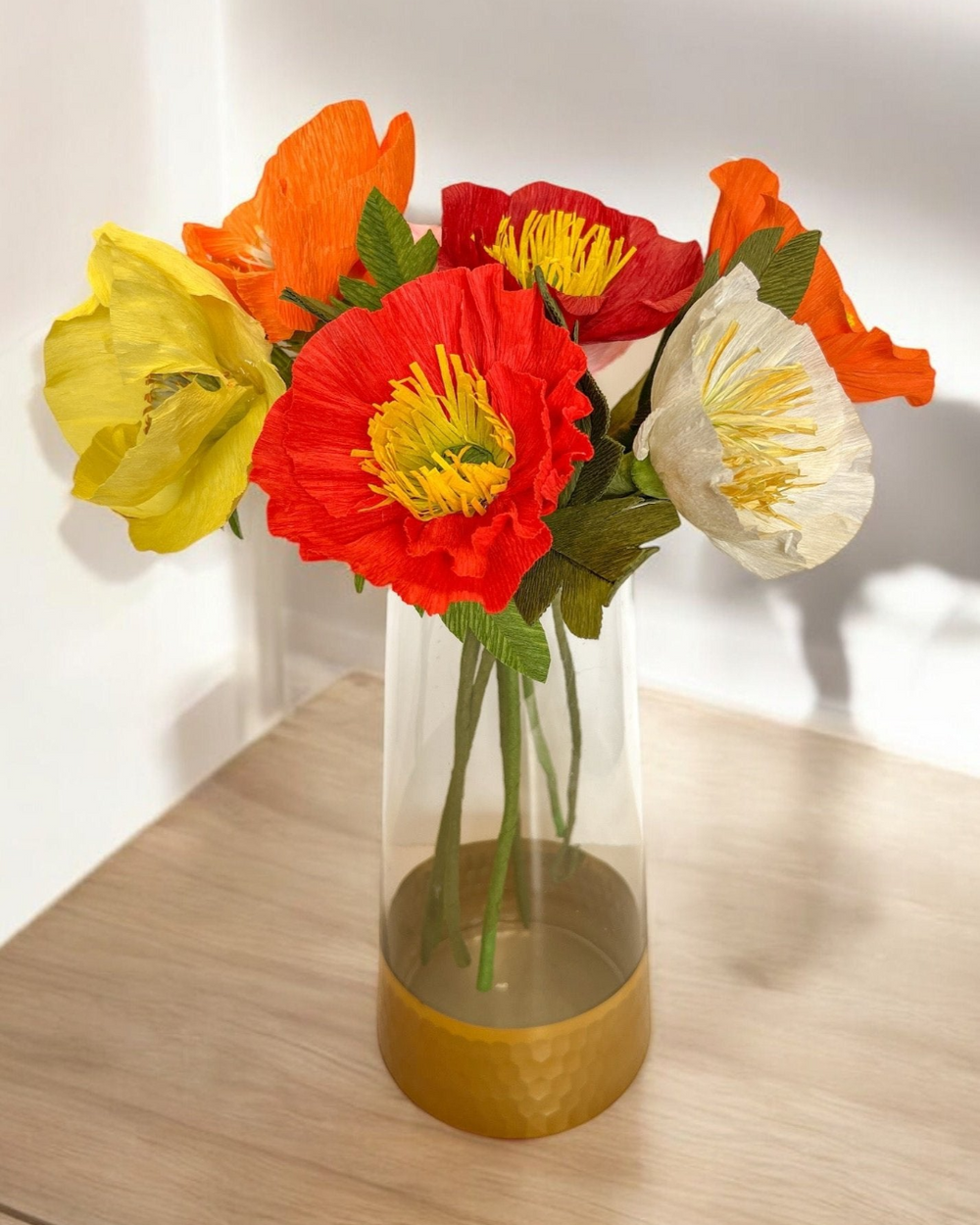 a vase filled with colorful flowers on top of a wooden table