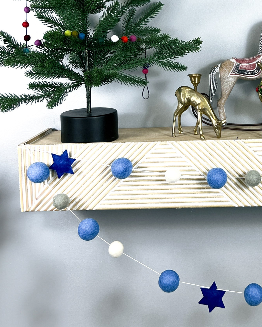 a wooden shelf with ornaments and a christmas tree
