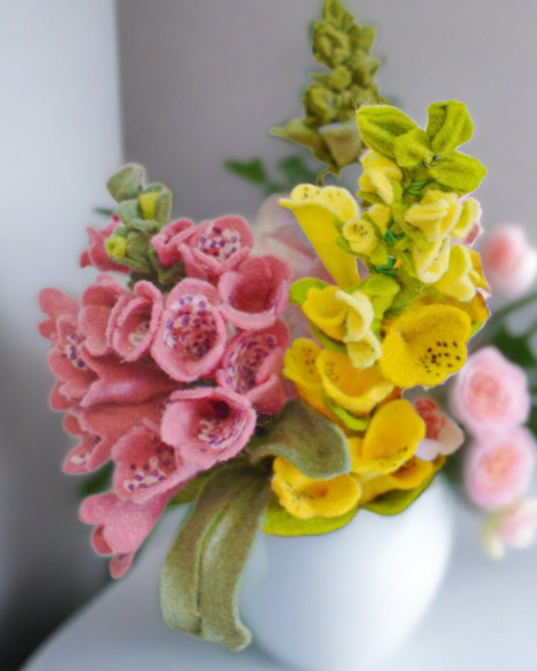 a white vase filled with flowers on top of a table