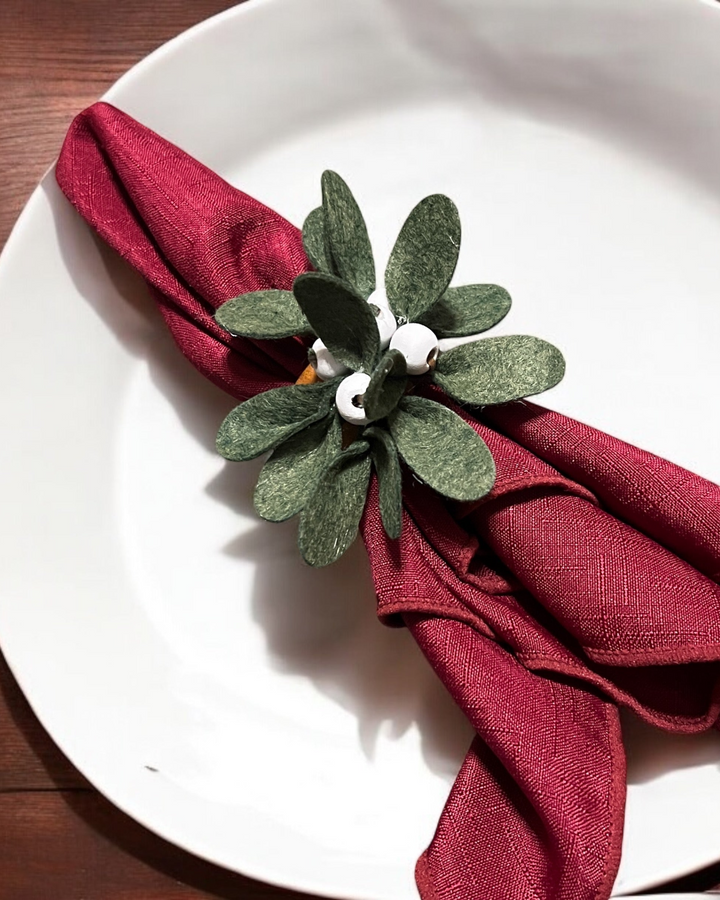 a white plate topped with a red napkin and a green flower