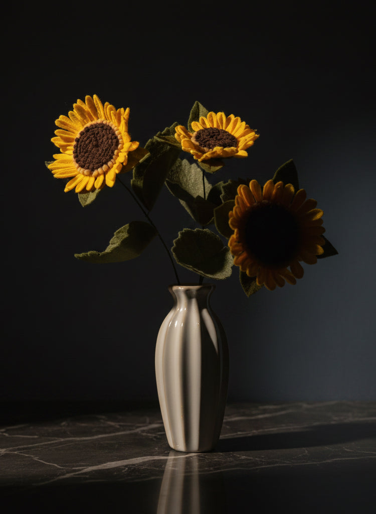 a white vase with three sunflowers in it