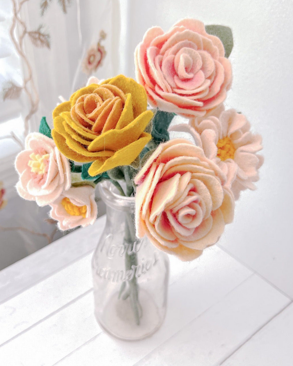 a glass vase filled with pink and yellow flowers