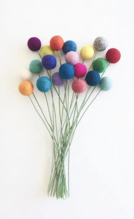 A bouquet of artificial felt pom-pom flowers in multiple colors, including purple, blue, red, green, pink, yellow, orange, and white, attached to thin green wire stems against a plain white background.