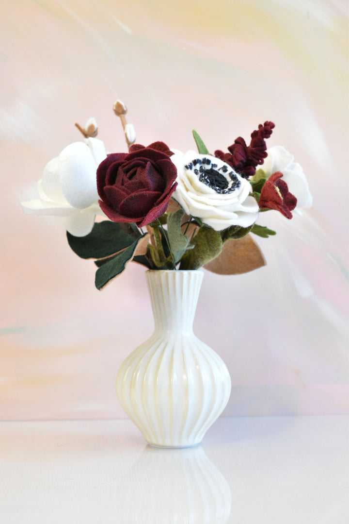 Melly Meier Botanicals handcrafted felt bouquet with deep burgundy and white magnolias, anemones, and ranunculus flowers.
