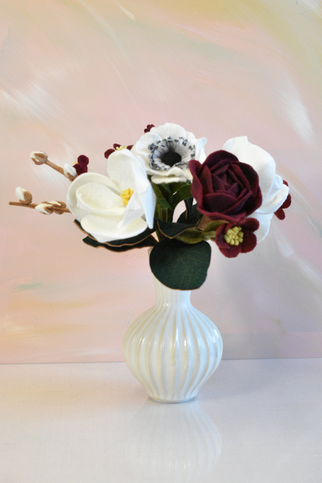 Melly Meier Botanicals handcrafted felt bouquet with burgundy and white magnolias, anemones, and pussy willow stems.